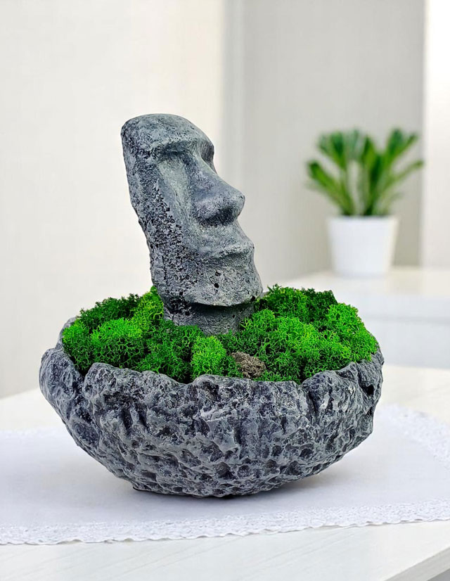 Betónová socha Moai z Veľkonočného ostrova,  zdobená stabilizovaným machom
